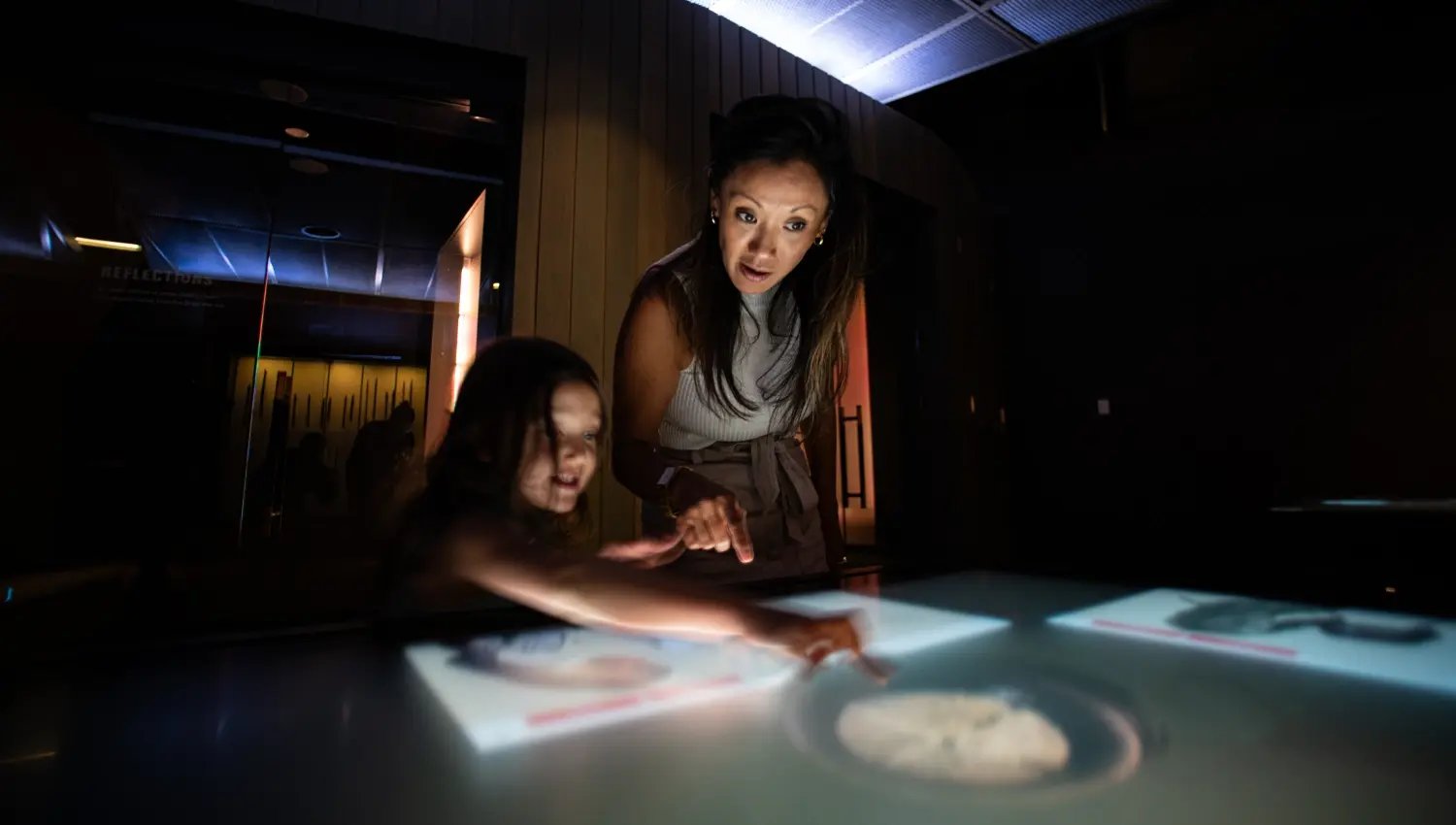 Guests interacting with a touch table at an Electrosonic built museum experience.