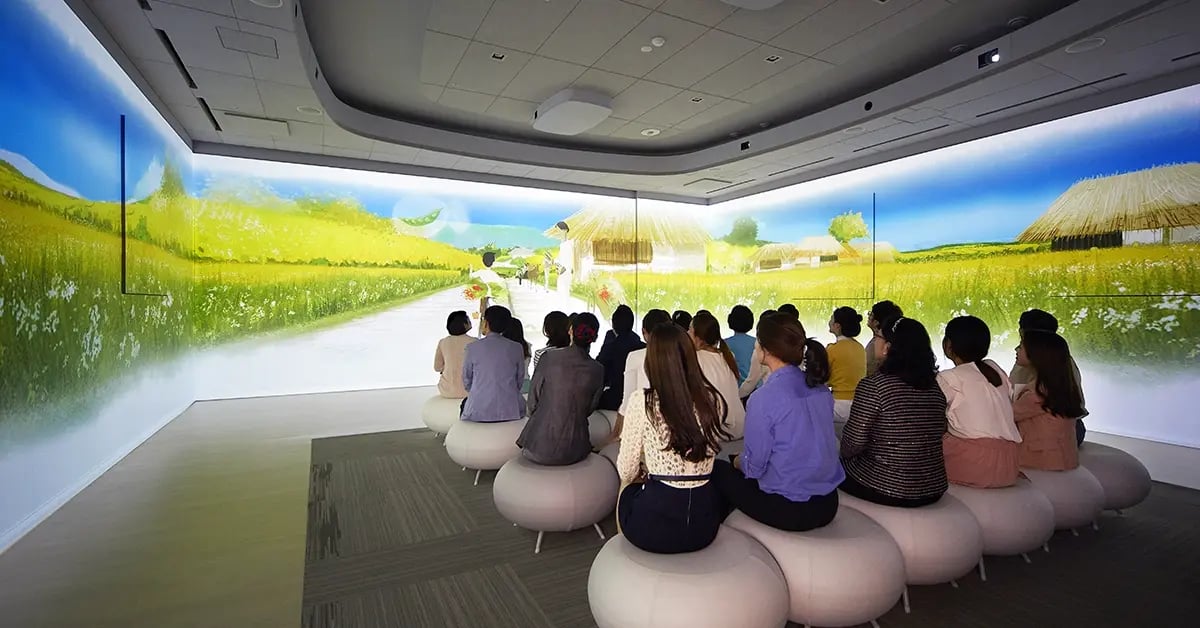 Guests sit inside an immersive room at Amore Pacific’s Beautiful Life Center, surrounded by calming visuals and storytelling experiences that celebrate beauty and wellness.