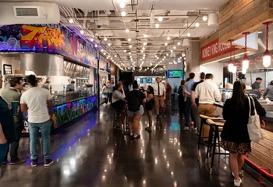 Guests to the Jaxon & The Exchange food hall in downtown Dallas enjoying themselves, walking throught he space looking for the right food and drink options.