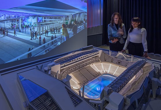 Two visitors to the NHL Seattle Preview Center experiencing the immersive arena preview space.