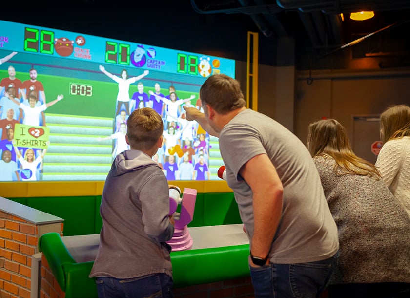 Dad and son playing games at the Mascot Hall of Fame.