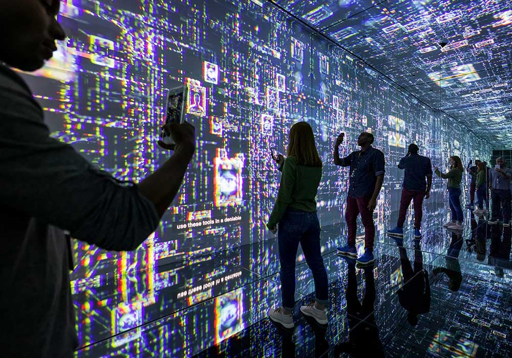 Guests to the International Spy Museum standing in the infinity room.