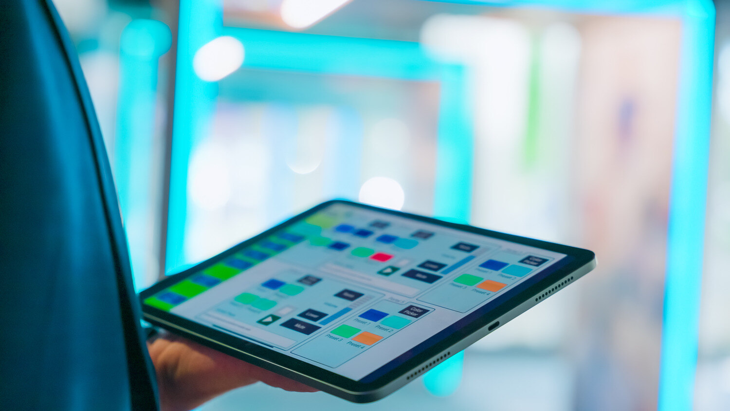 A person holding a tablet that displays various icons.