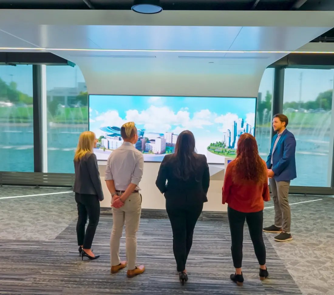 Visitors to the Johnson Control's customer experience center engaged with an AV exhibit within the main presentation space.
