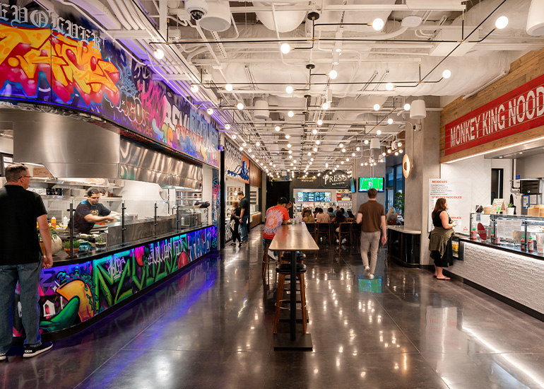 Patrons to the Jaxon & Exchange food hall in Dallas Texas walking through and purchasing food.