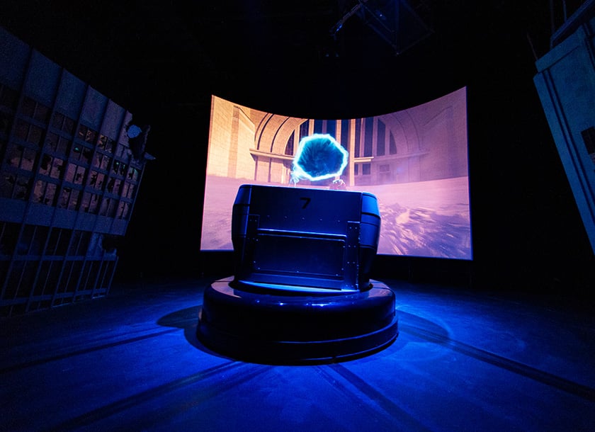 Ride vehicle parked in front of a screen at the Justice League Warworld Attack dark ride at Warner Bros. World Abu Dhabi.