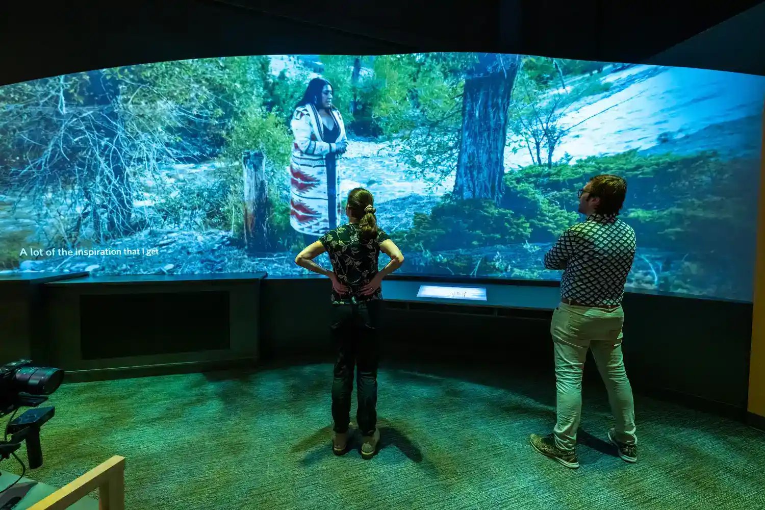 Two people looking at a curved LED wall.