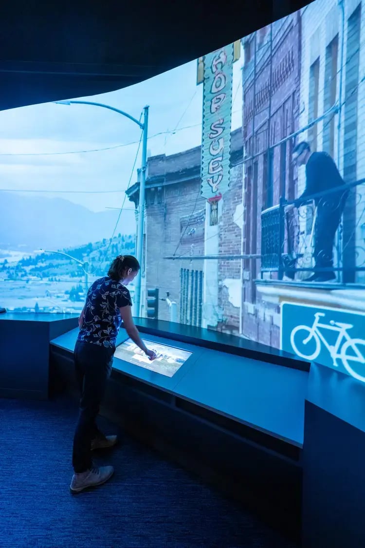 Woman interacting with LED touchscreen and technology.