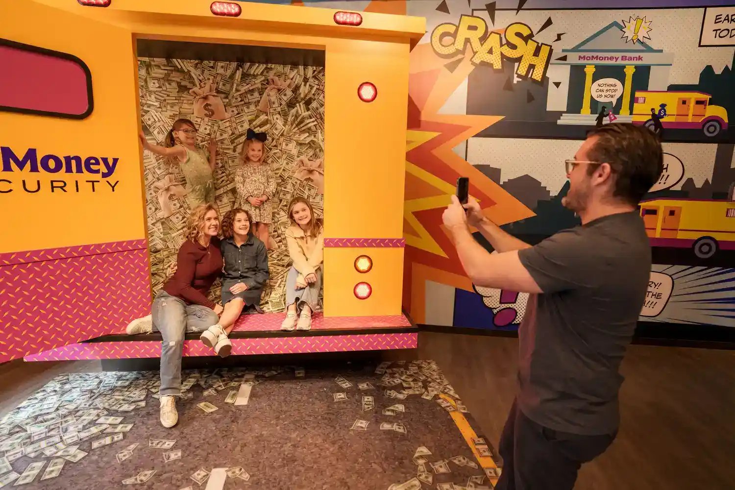 Man taking picture of people in money truck.