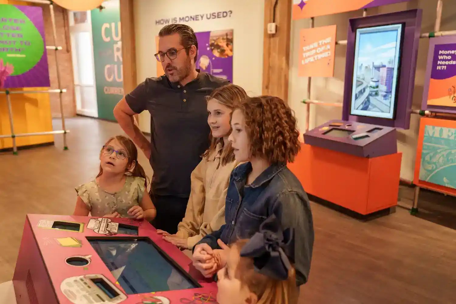 Family playing with touchscreen while looking at a display.