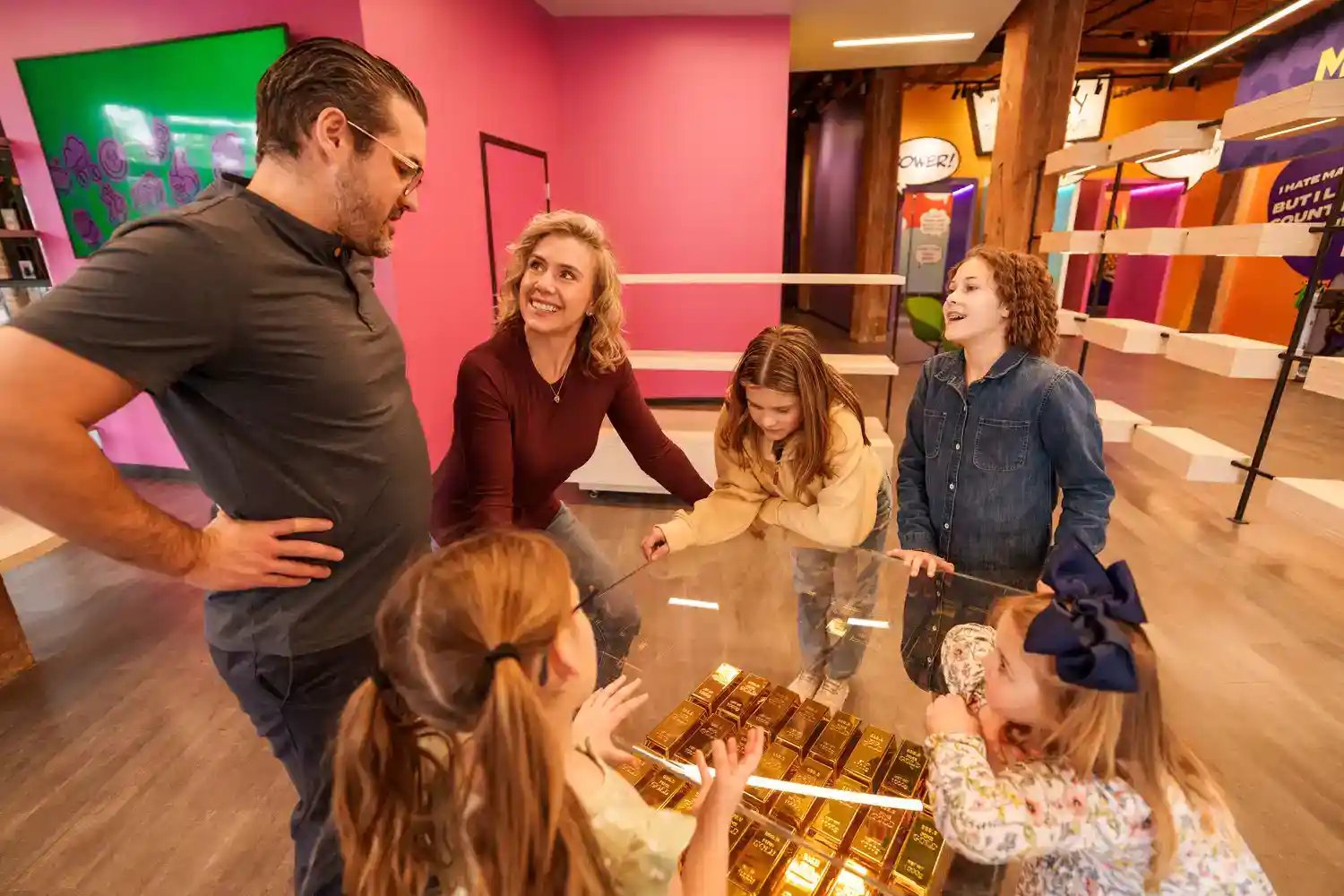 Group of people looking at a display of gold bars.