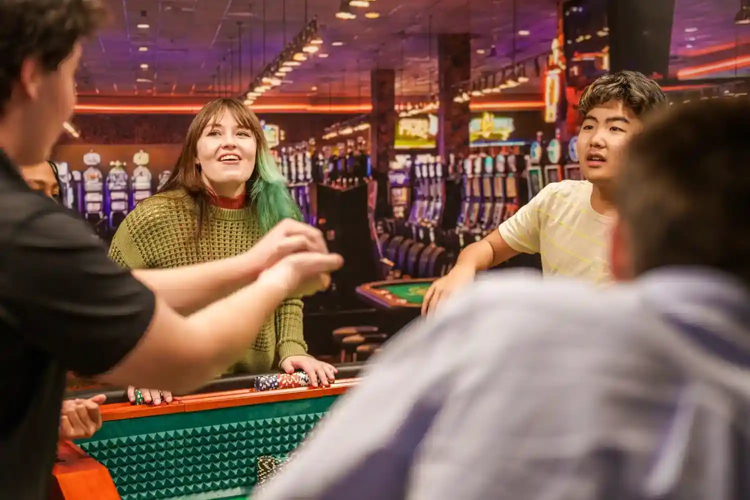 Group of people talking over pool table.