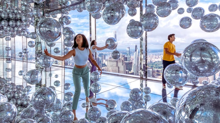 Guests at Summit One Vanderbilt playing with mirrored balls.