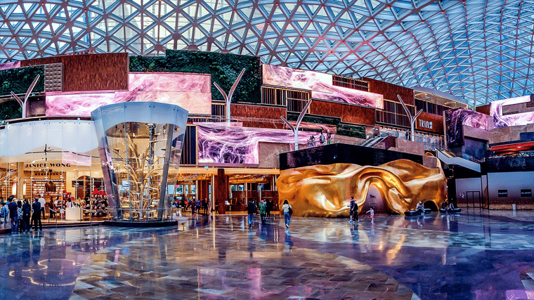 Wide-angle view of The Spectacle’s soaring atrium, showcasing its LED ceiling canopy, lush indoor greenery and immersive digital displays.