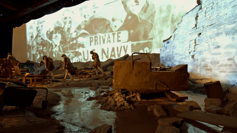 Photograph of the Trenches Exhibit at the National WWI Museum and Memorial, depicting a realistic trench scene with period artifacts and dim, atmospheric lighting.