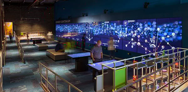 Guests interacting with touch tables and touchscreens at the National Comedy Center.