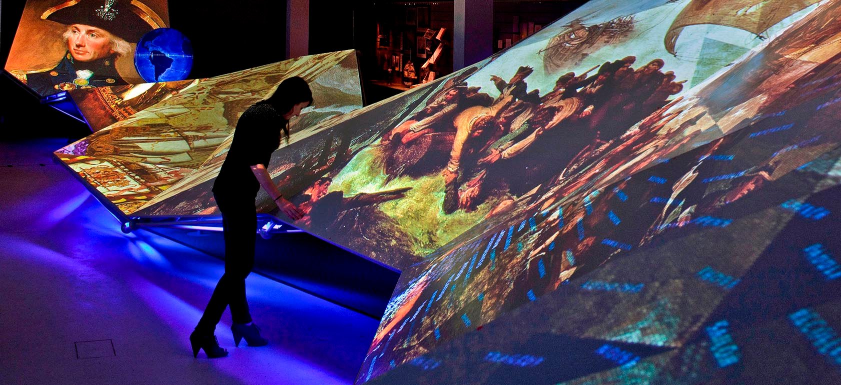 A visitor looks at changing patterns of images and words on a massive dynamic wavelike structure at London’s National Maritime Museum.