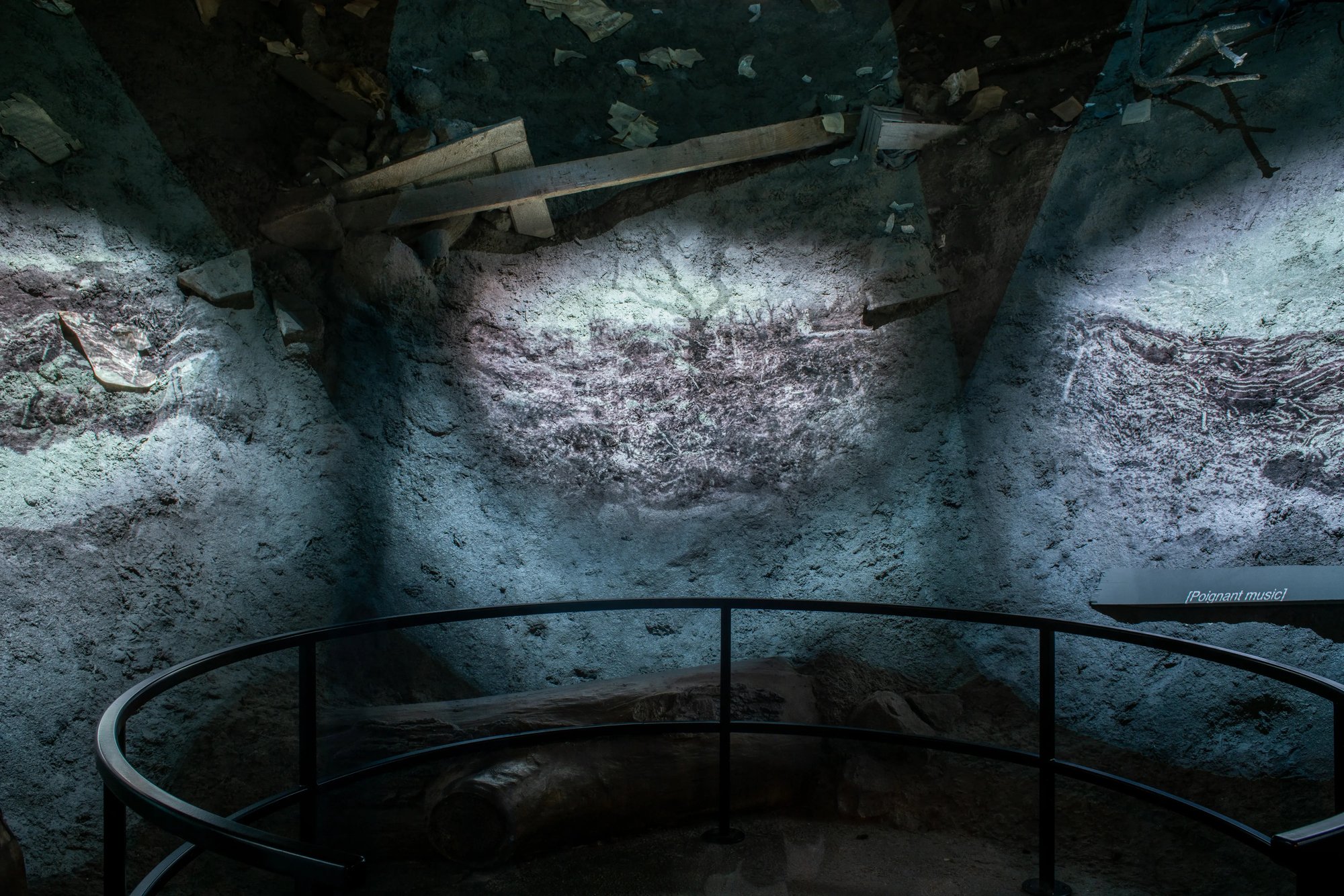 A crater with media and a ship hanging from the ceiling.