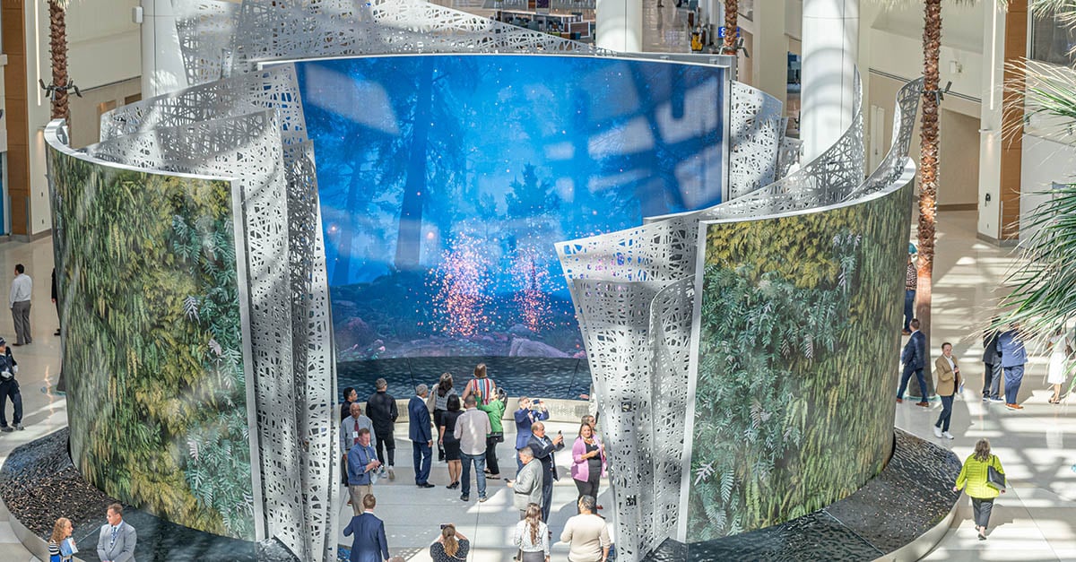 Guests to the Orlando International Airport Terminal C walking past and viewing the digital activation which is comprised of three dual-sided LED walls.