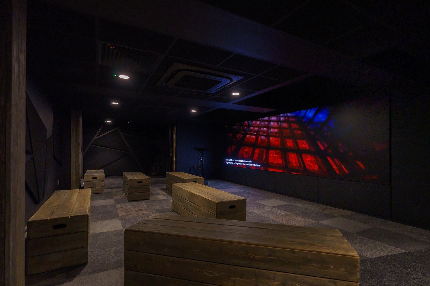 A back side angle of a room with a video wall in the front and centered.