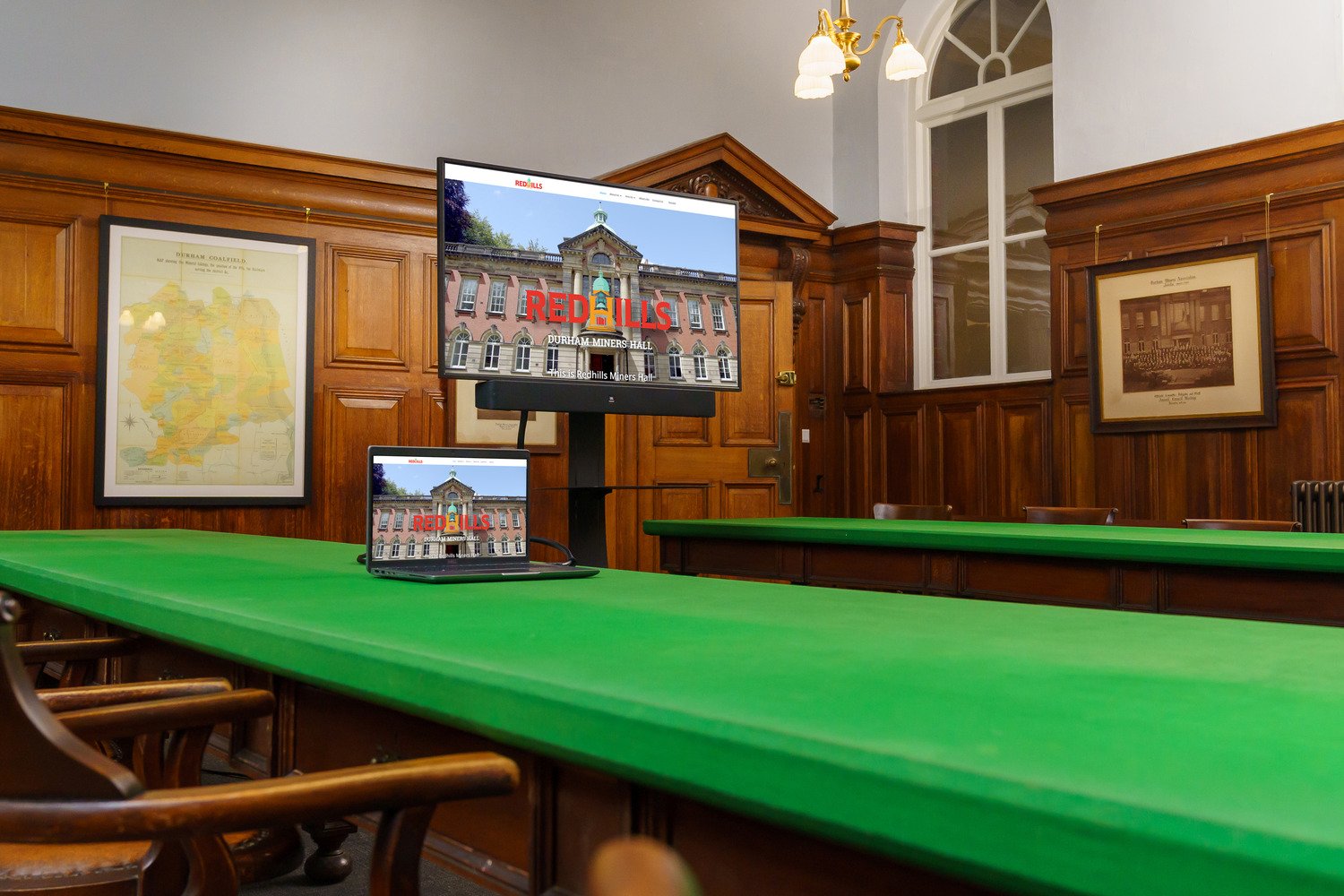 The committee room that has a screen on a mobile trolley and a laptop.