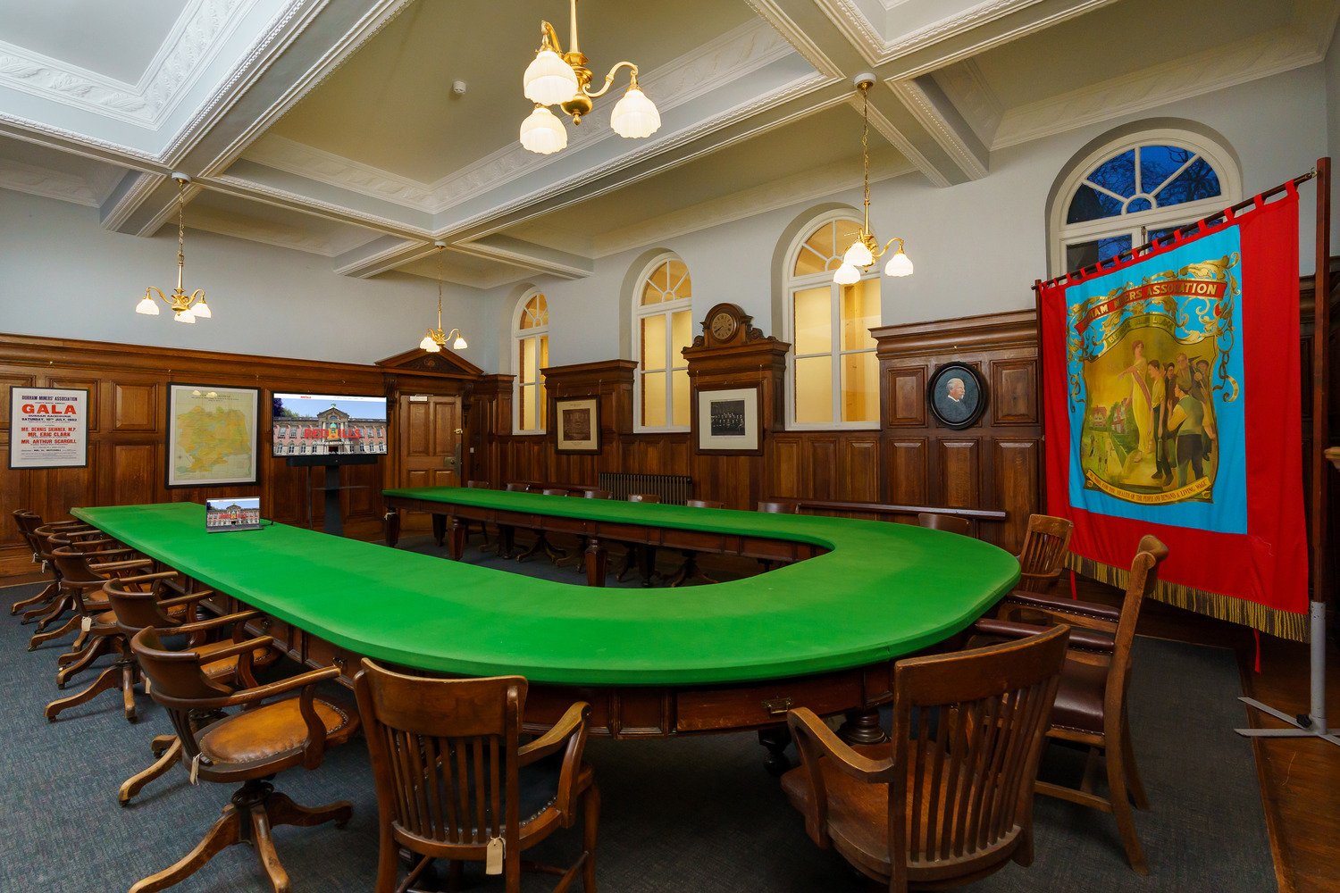 The committee room that has a table, memorabilia and screens with the Redhills website.