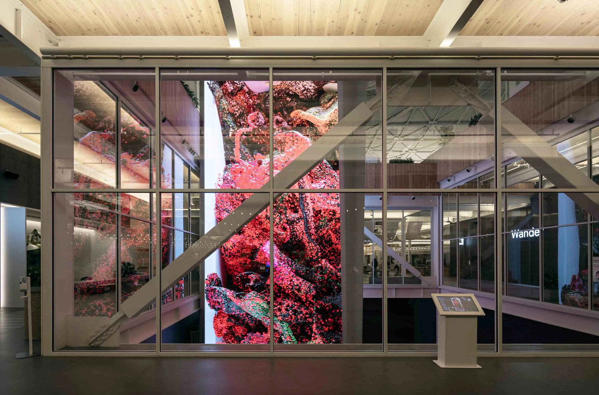 Refik Anadol displayed through a glass walkway