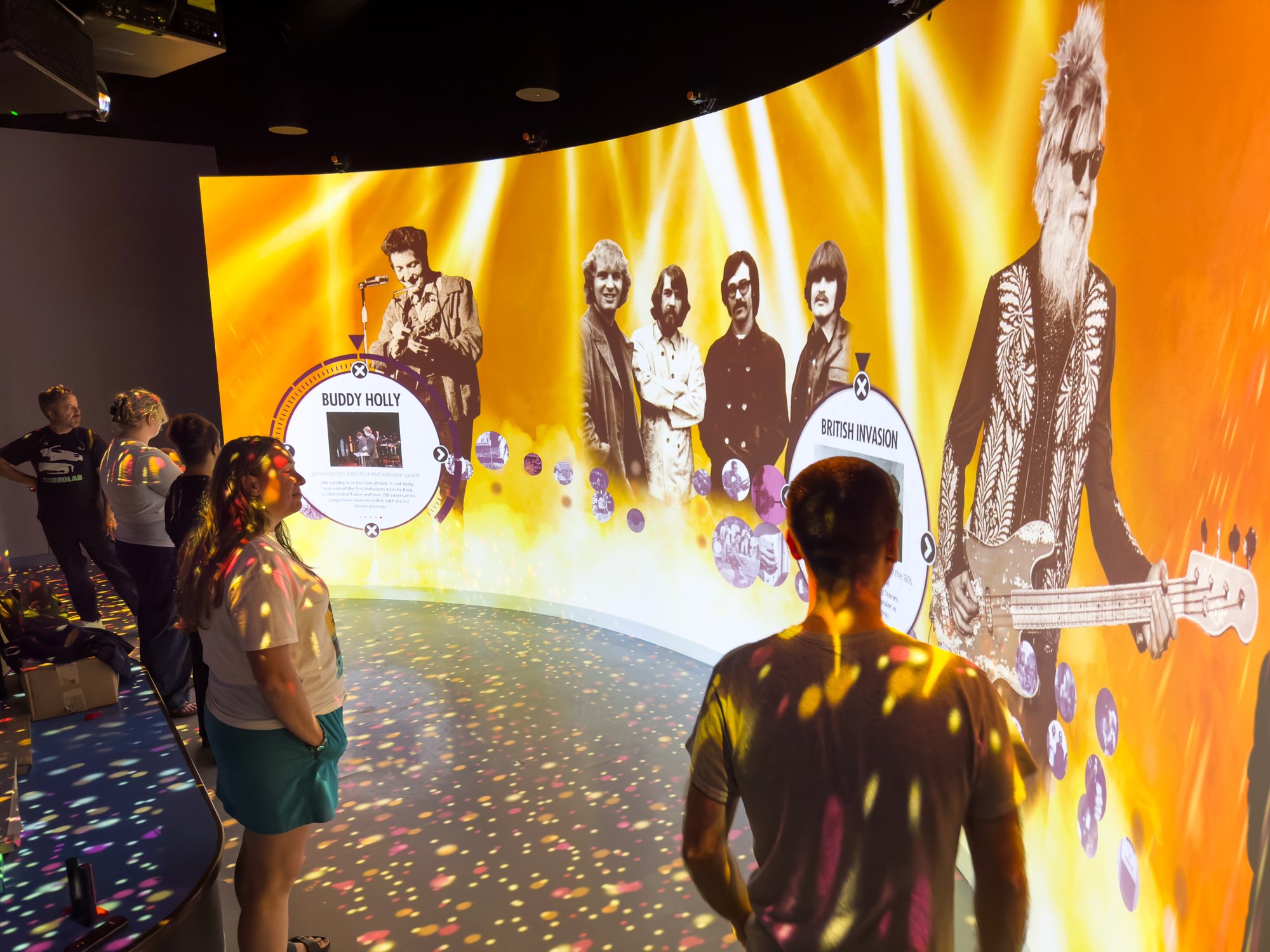 A group of people looking at a curved projection wall.
