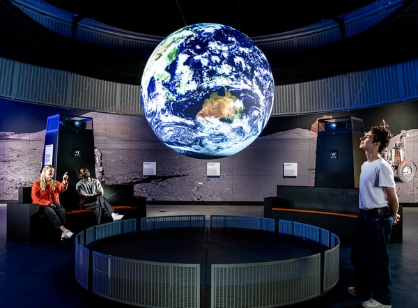 People looking up at Science on a Sphere