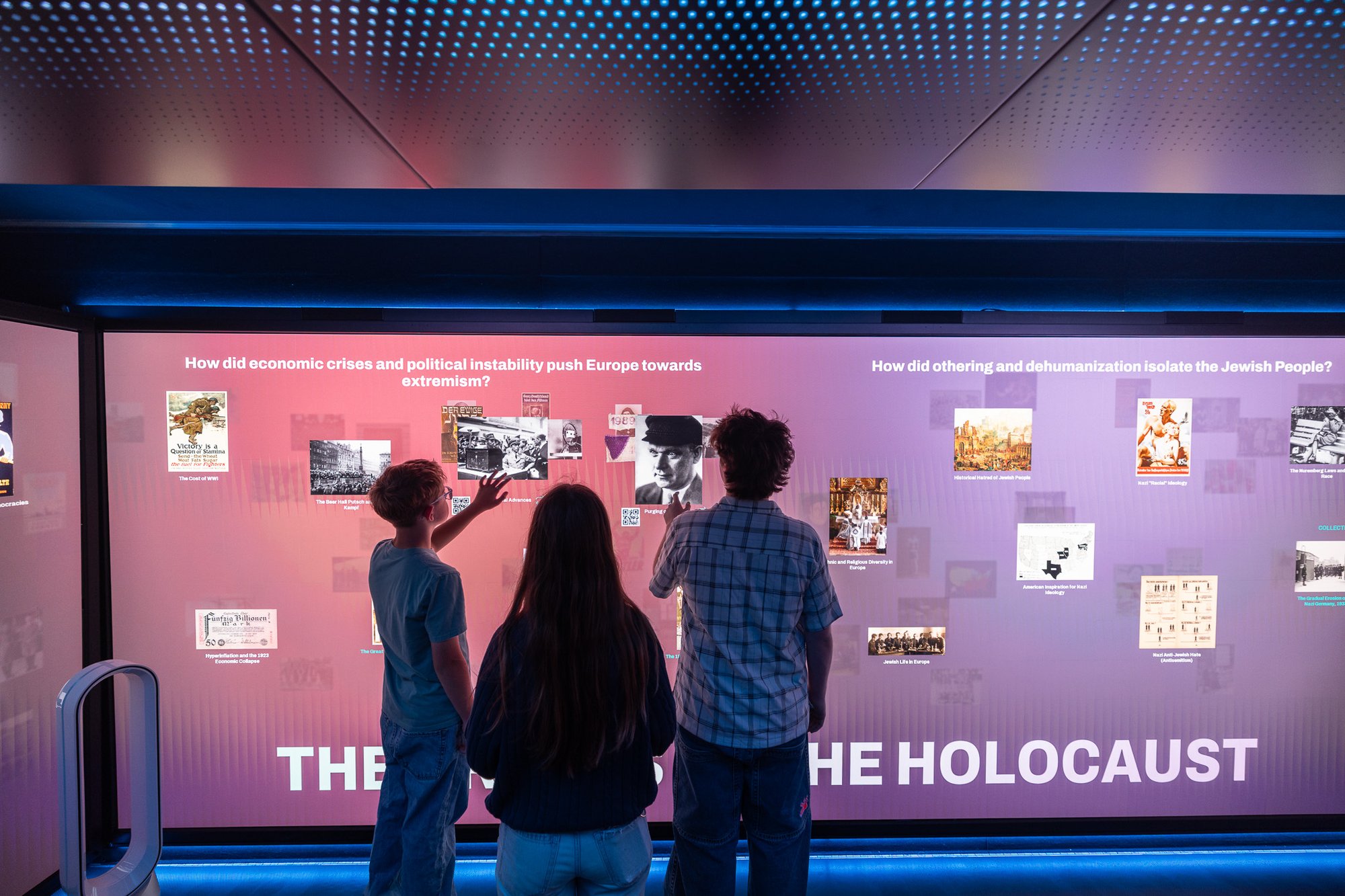 A group of three people interacting with touchscreen.