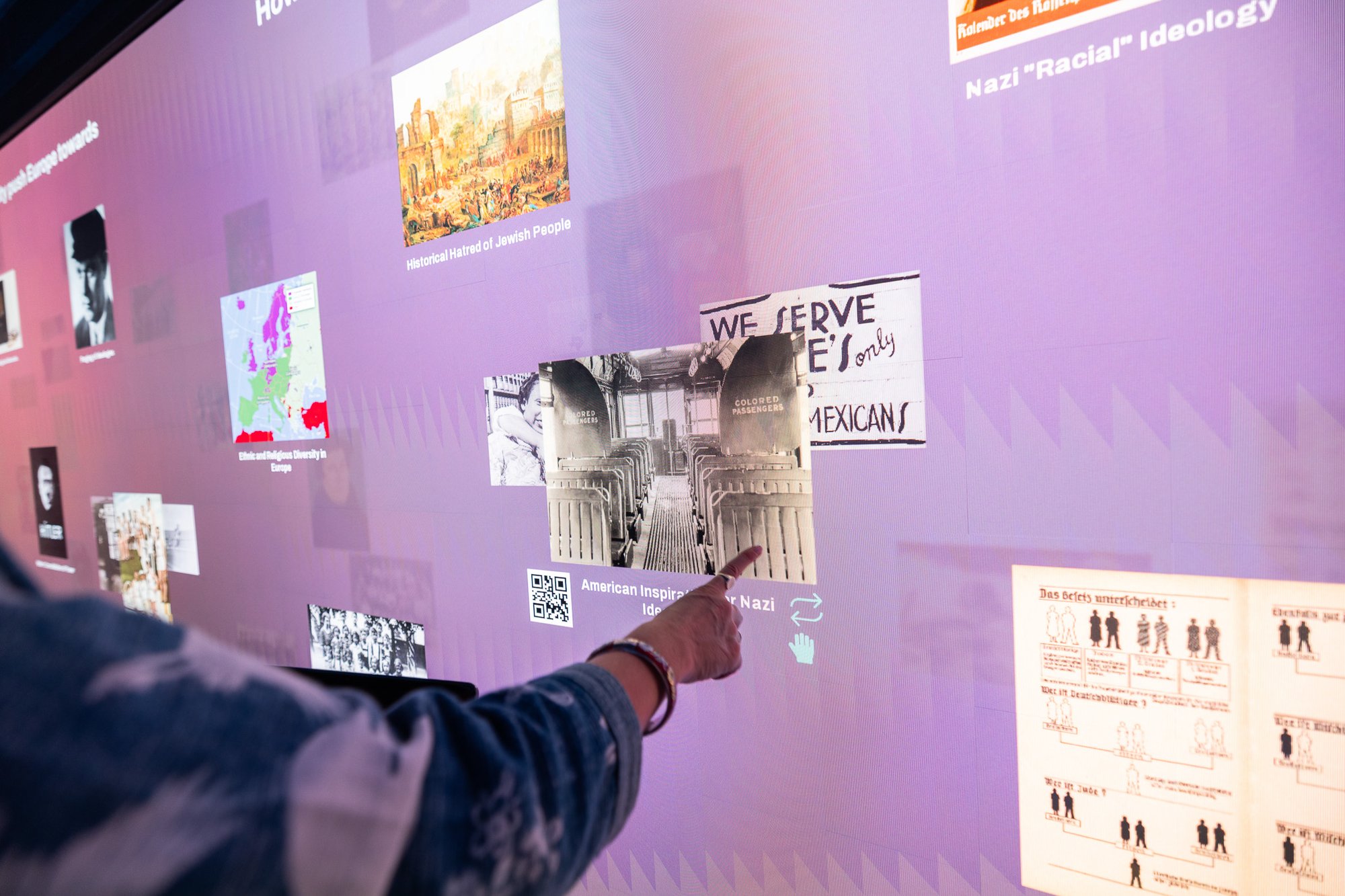 A person pointing at media on a LED wall.