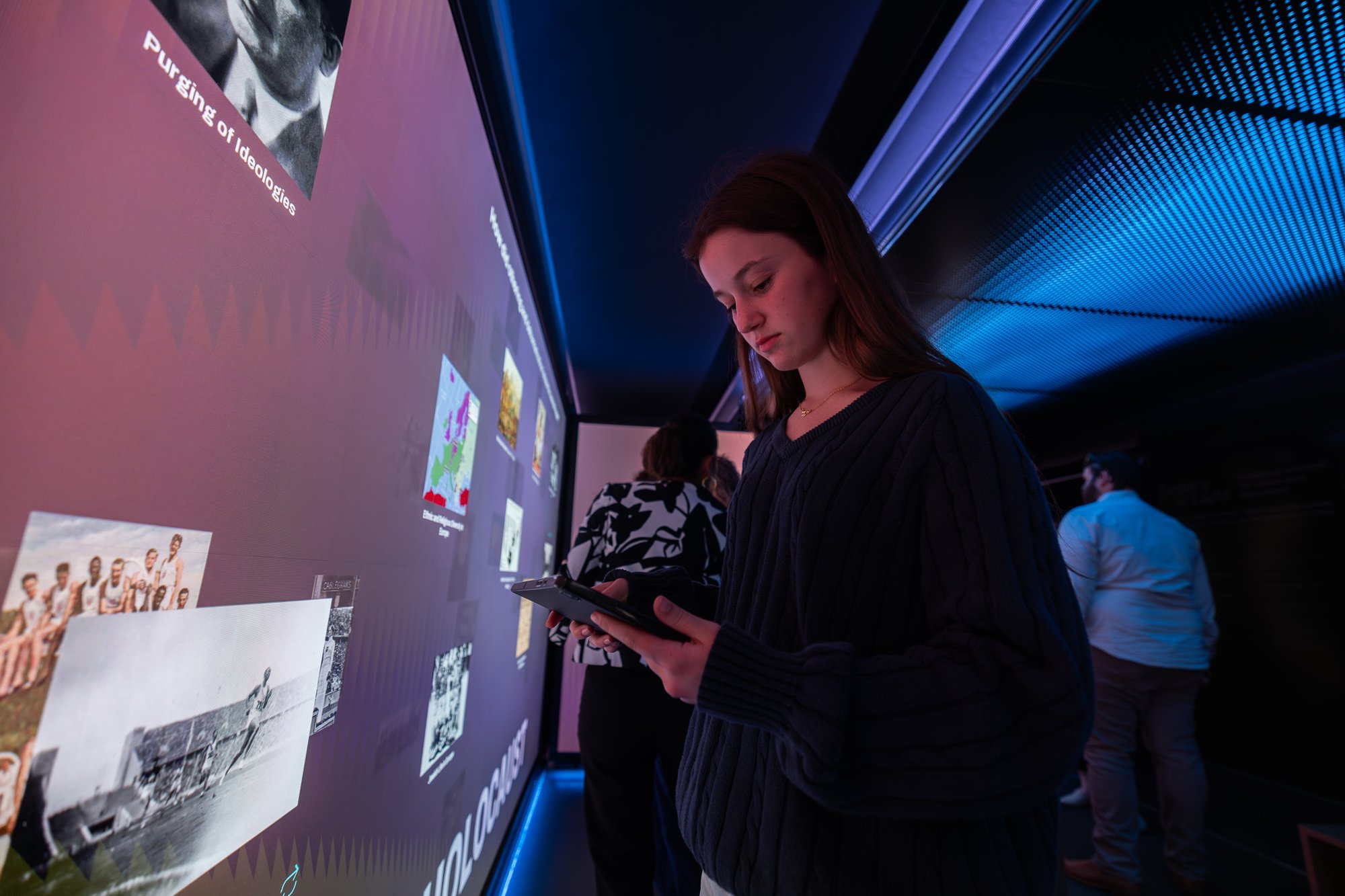 A girl touching a tablet in front of the LED wall