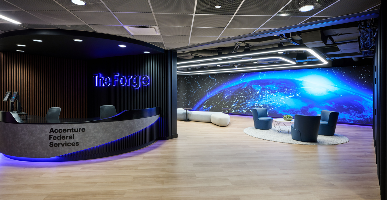 The entrance of the building with the welcome desk on the left and a LED video wall on the right.