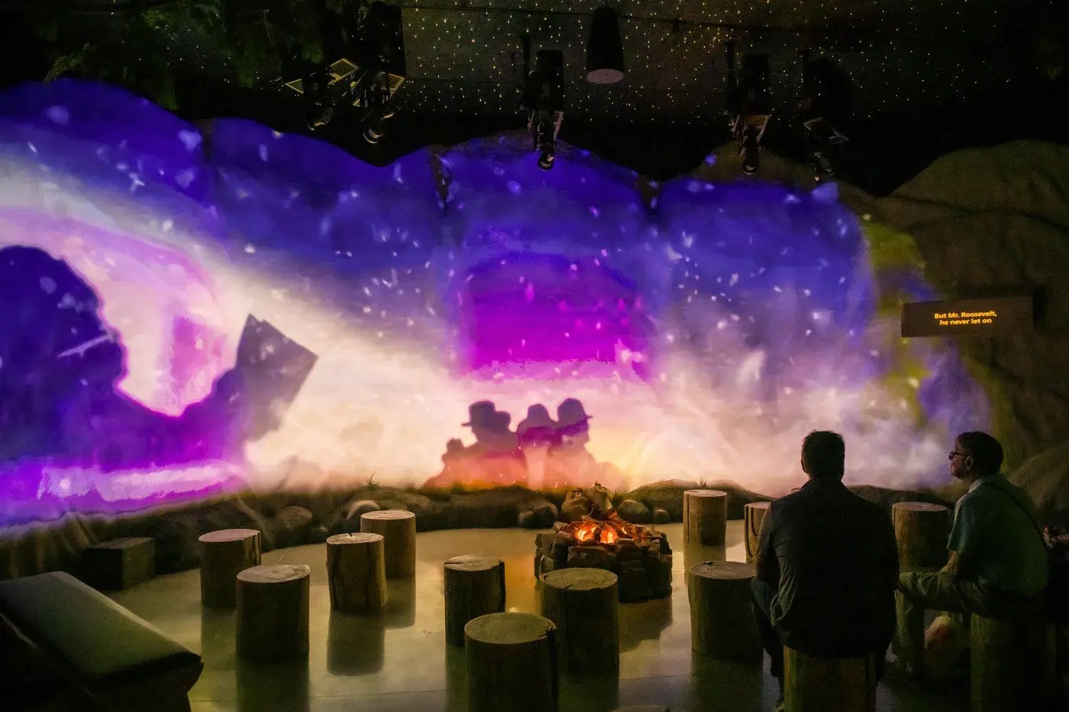 Two men looking at projection on wall.