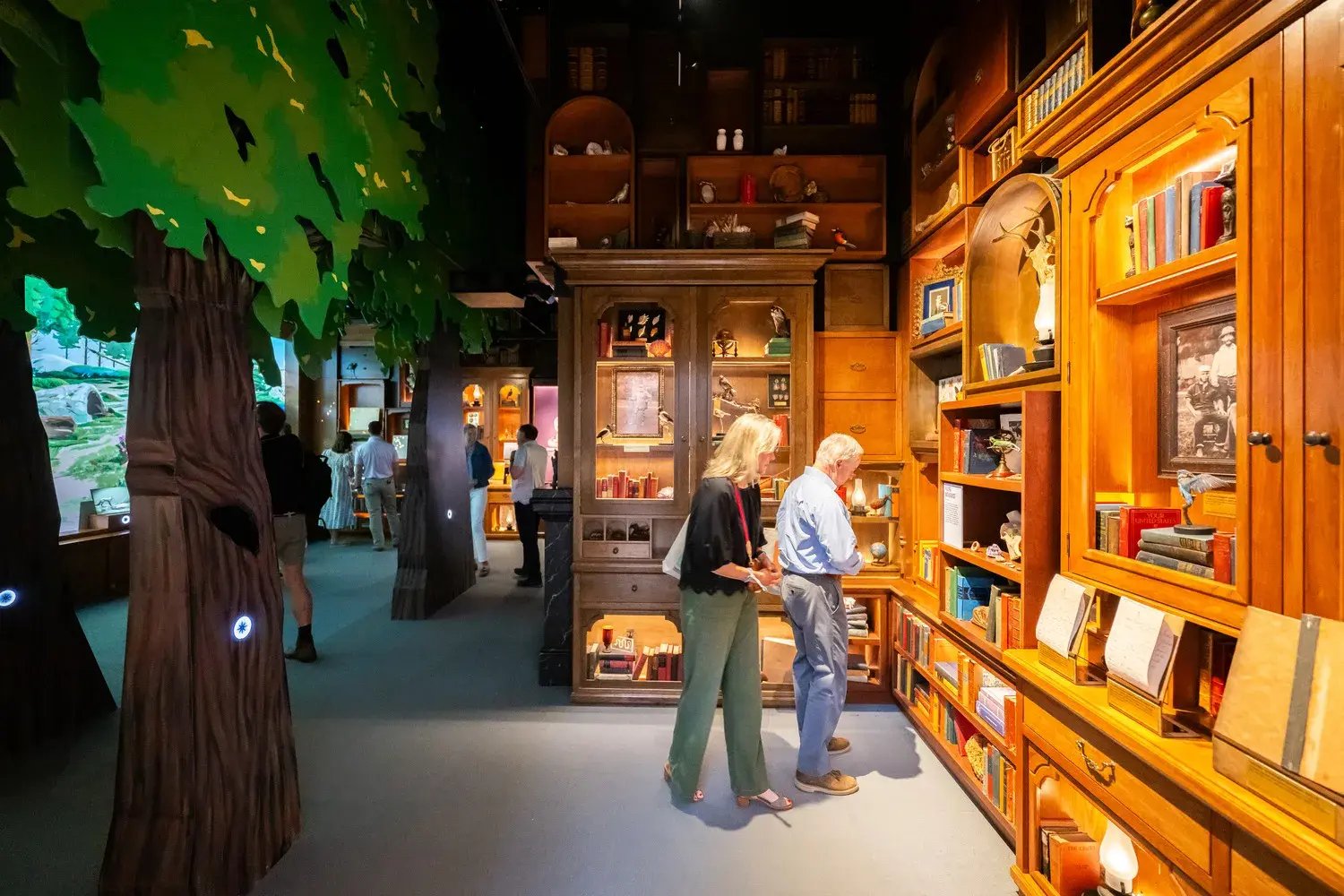 Two people interacting with the artifacts on the wall.