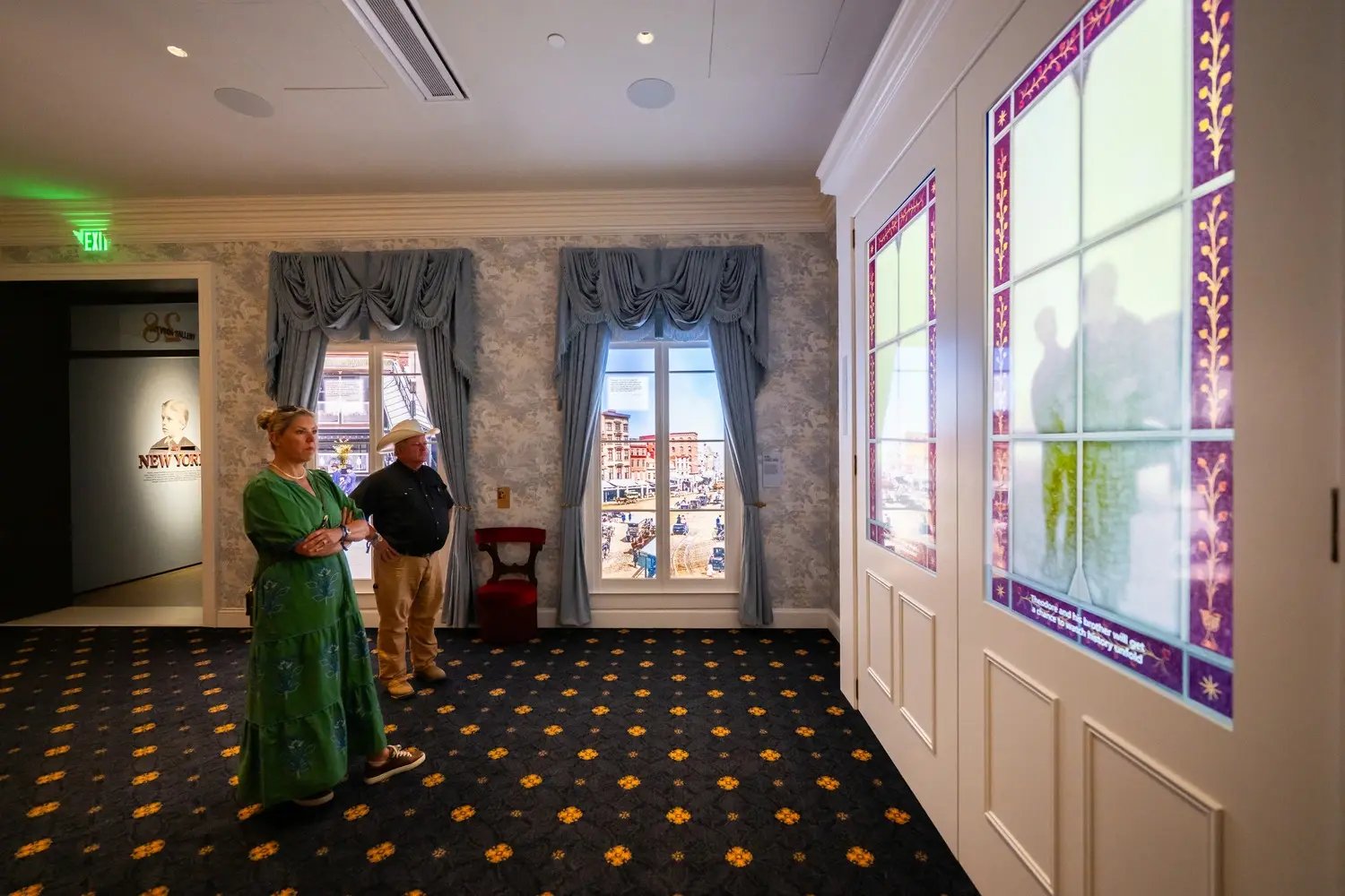 Two people watching window with LED display.