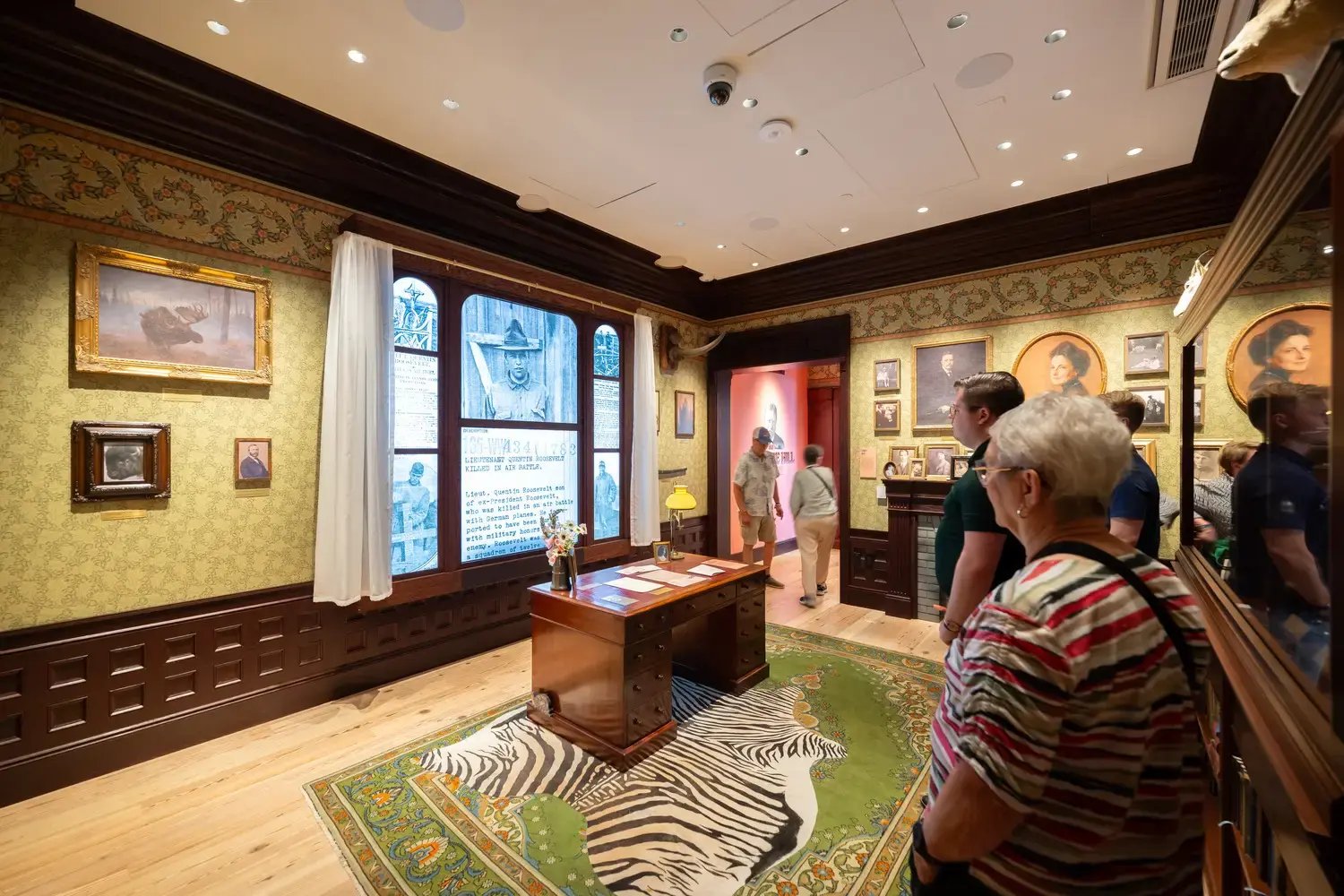 Group of people viewing Roosevelt's home desk display.