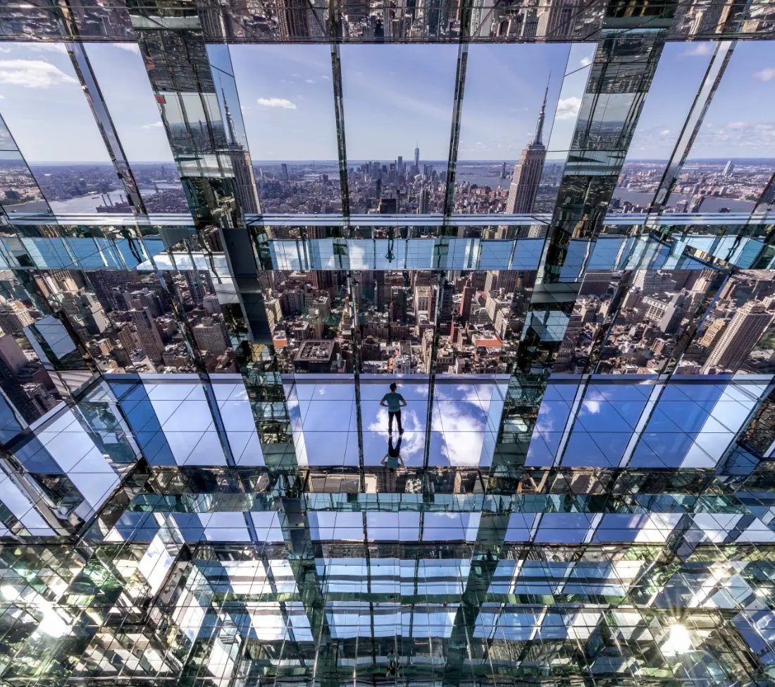 A guest to Summit One Vanderbilt's infinity room looking out to the views of NYC.