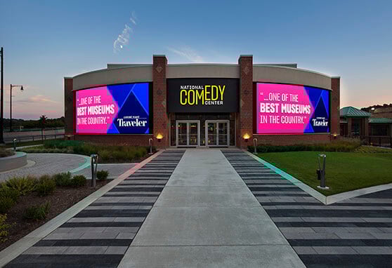 The exterior of the National Comedy Center which welcomes visitors with vibrant digital signage, celebrating its acclaim as one of the best museums in the U.S.