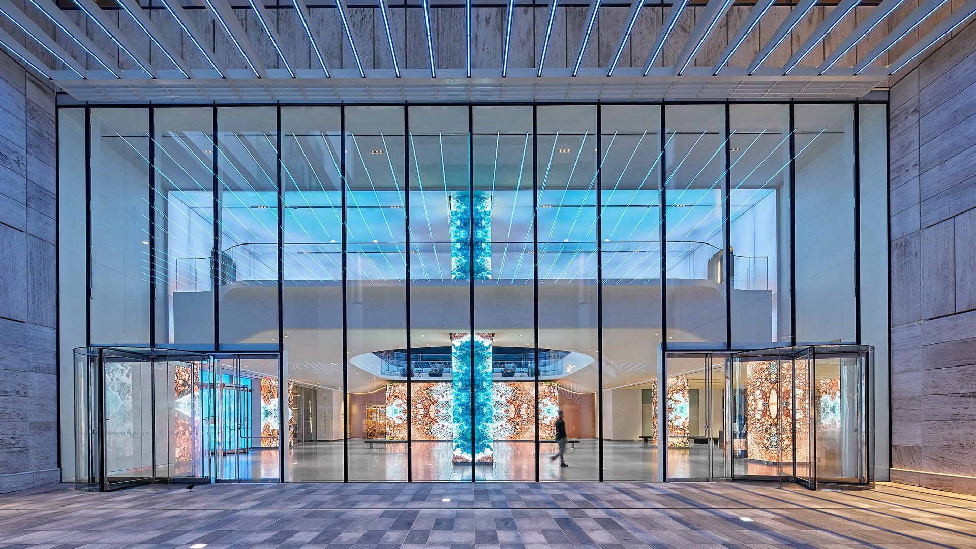 The glass façade of this modern lobby reveals a stunning, immersive LED installation with vibrant digital art and blue-lit ceilings.