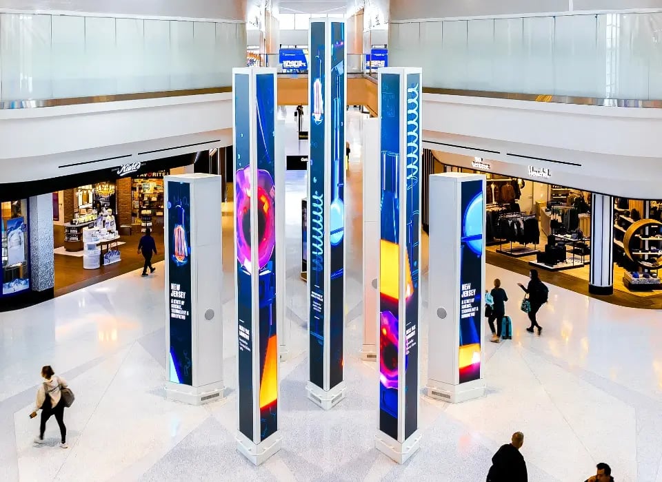 Travellers walking past a large digital sculpture at the Newark International Airport.-1