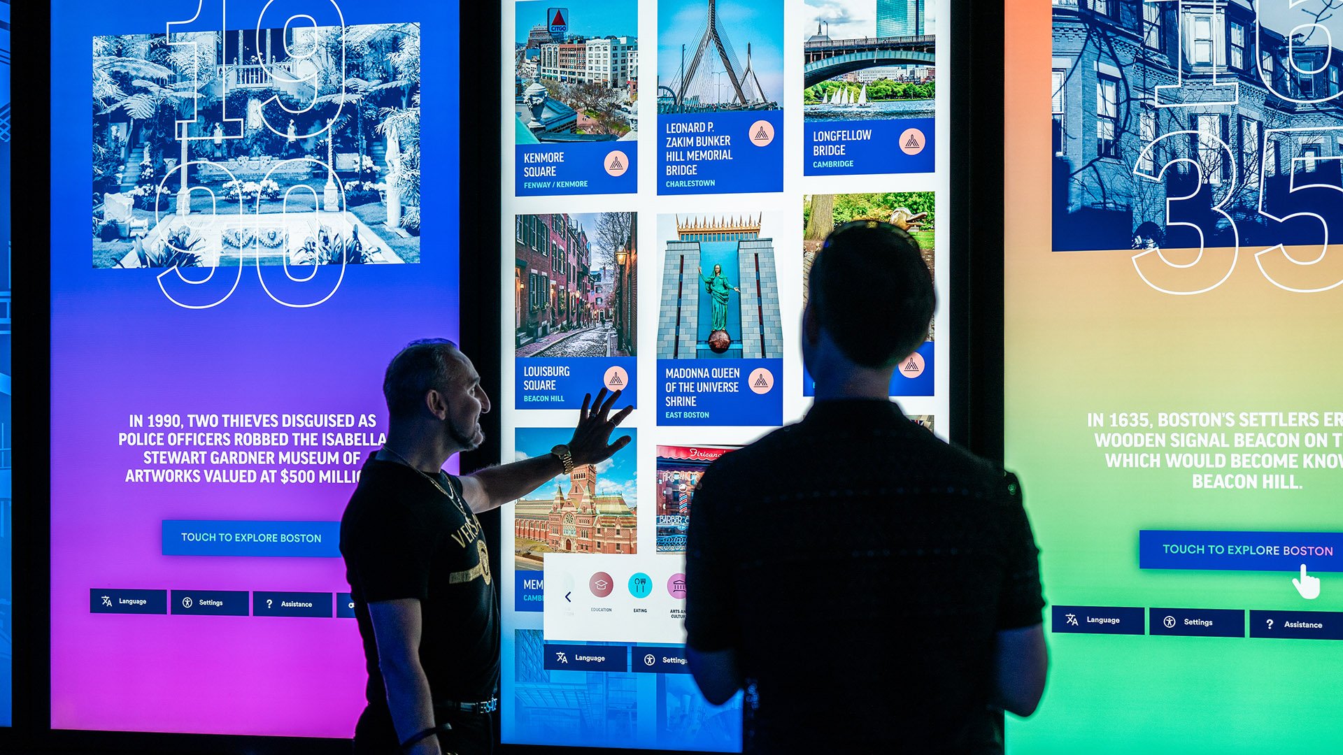 Two visitors to View Boston interacting with a touch screen.