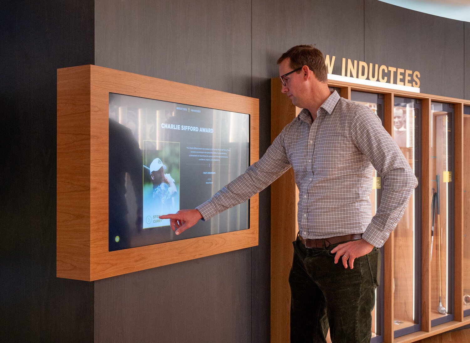 A man touching the screen in a exhibit