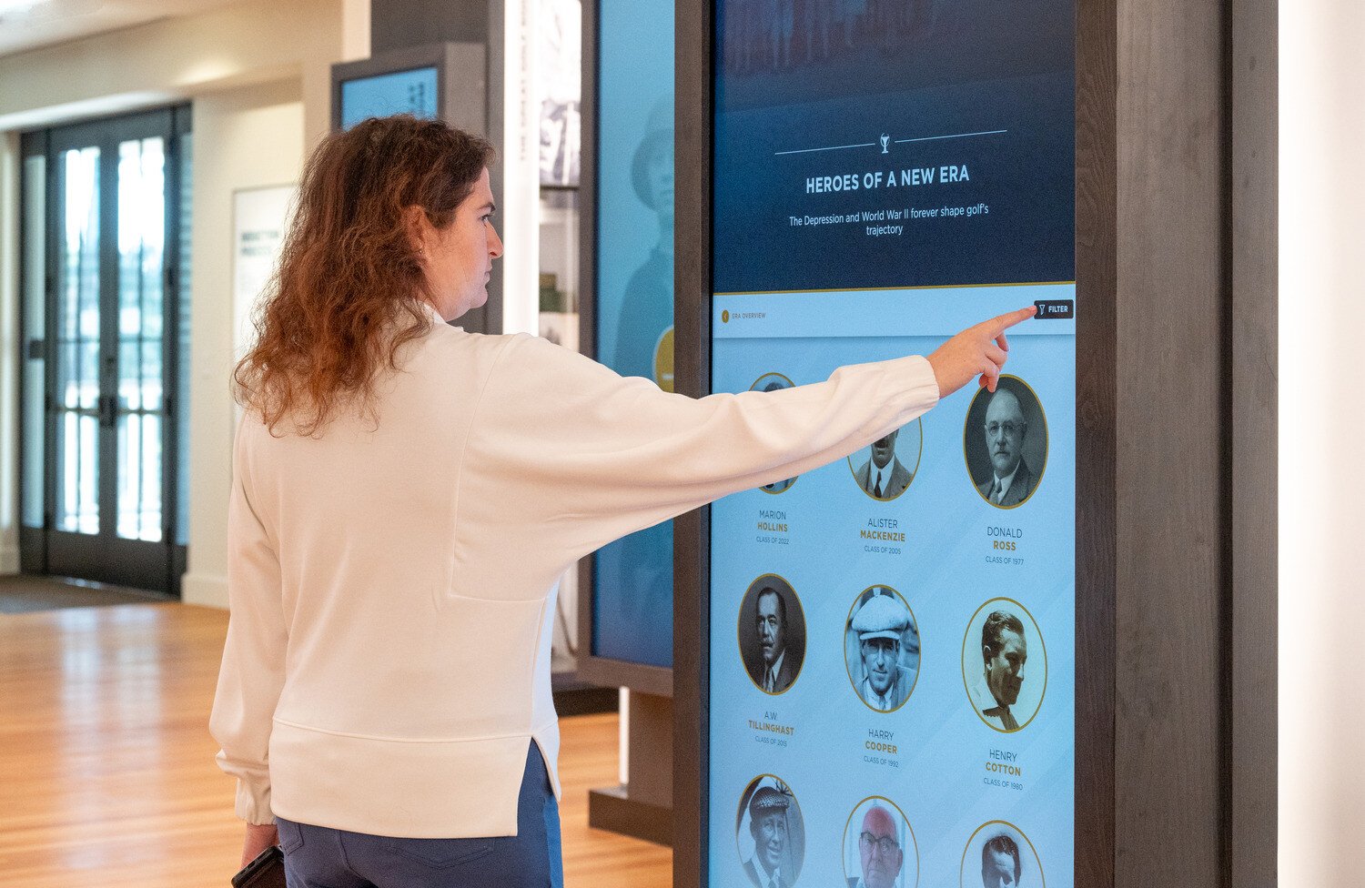 A women using the interactive screen near the entrance of the building
