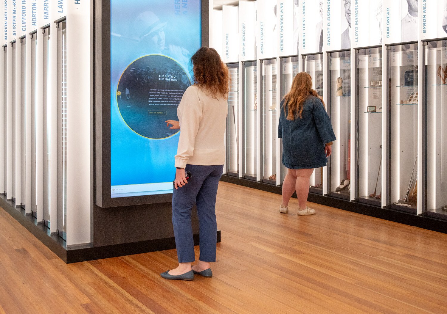 Women touching the videowall in the lockers exhibit