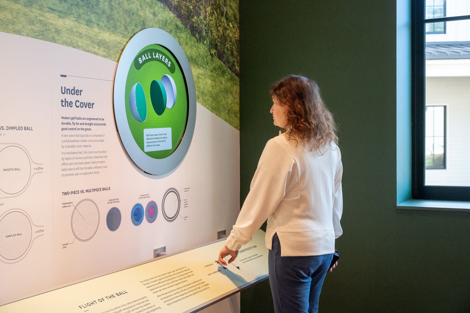 Woman reading the wall in the Science of Golf room