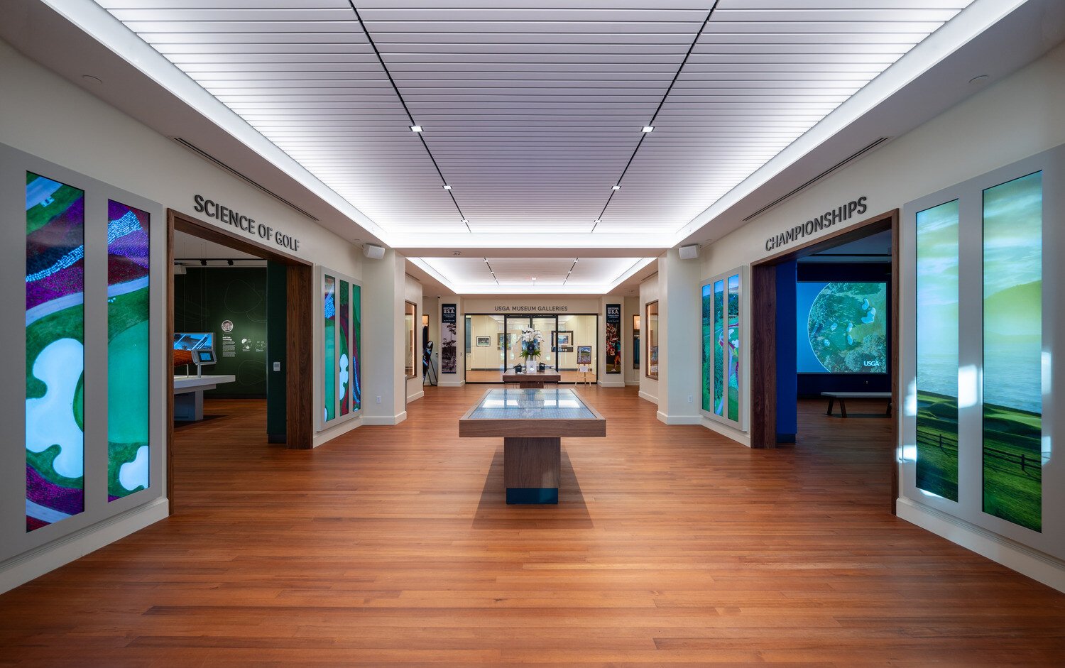 Middle view of the championships room on the right, a science of gold room on the left with a table in the middle