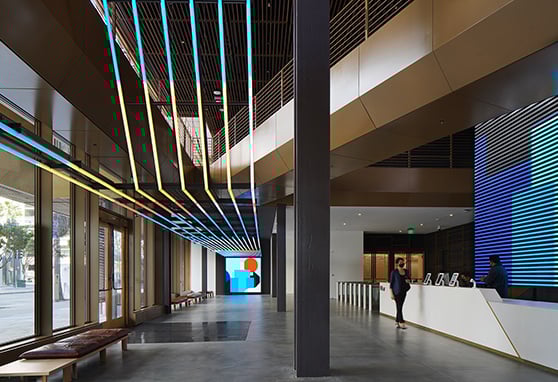 Ubers modern lobby that blends sleek architecture with vibrant digital art, featuring a colorful suspended light installation and dynamic LED displays that energize the space.-1
