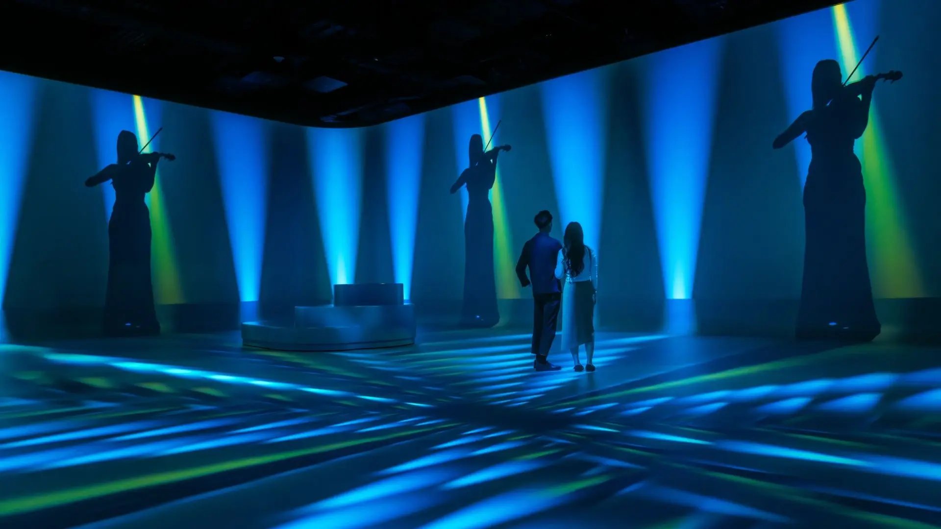 Two visitors to the Illuminarium experience viewing a show where audio plays a central role.