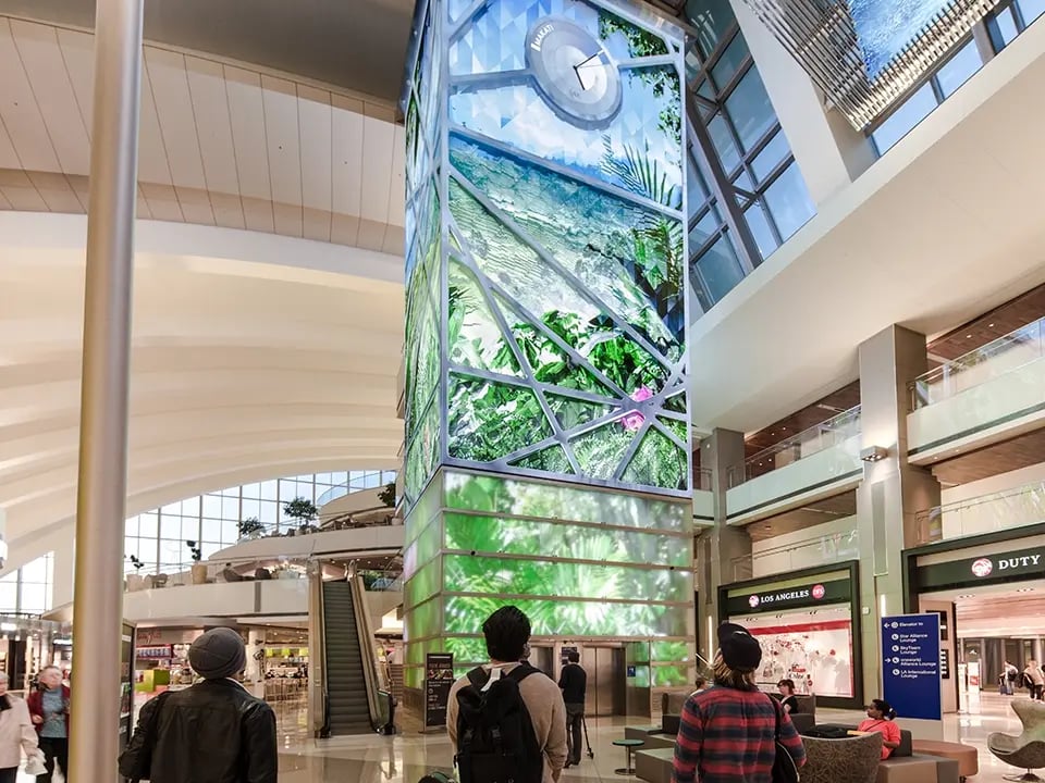 Visitors looking in awe of a highly experiential AV experience within an airport terminal.